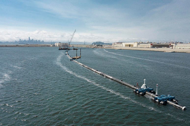 AP18250791823574 In this Monday, Aug. 27, 2018 photo provided by The Ocean Cleanup, a long floating boom that will be used to corral plastic litter in the Pacific Ocean is assembled in Alameda, Calif. Engineers will deploy a trash collection device to corral plastic litte
