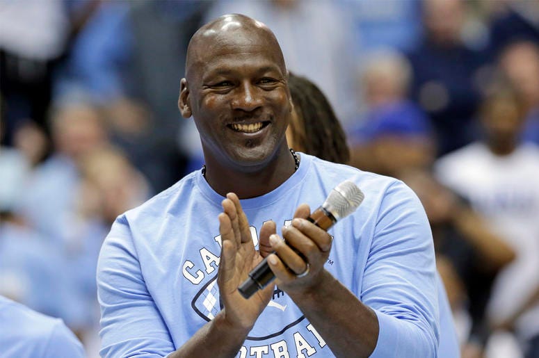 AP18261701684313 In this March 4, 2017, file photo, former North Carolina basketball player Michael Jordan applauds during a half-time presentation at an NCAA college basketball game between North Carolina and Duke in Chapel Hill, N.C. Jordan, who played high school baske