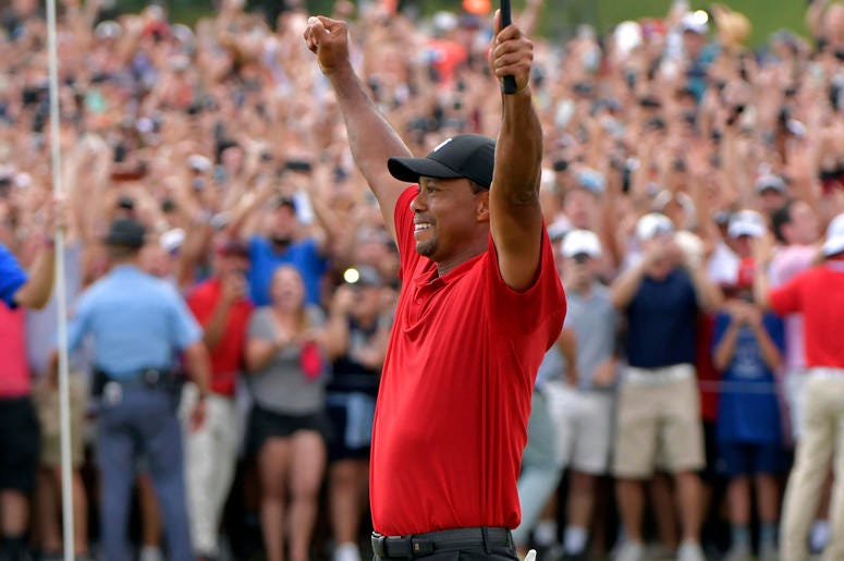 AP18266857857922 Tiger Woods celebrates after picking up his putt for par on the 18th green to win the final round of the Tour Championship golf tournament Sunday, Sept. 23, 2018, in Atlanta. (Hyosub Shin/Atlanta Journal-Constitution via AP)