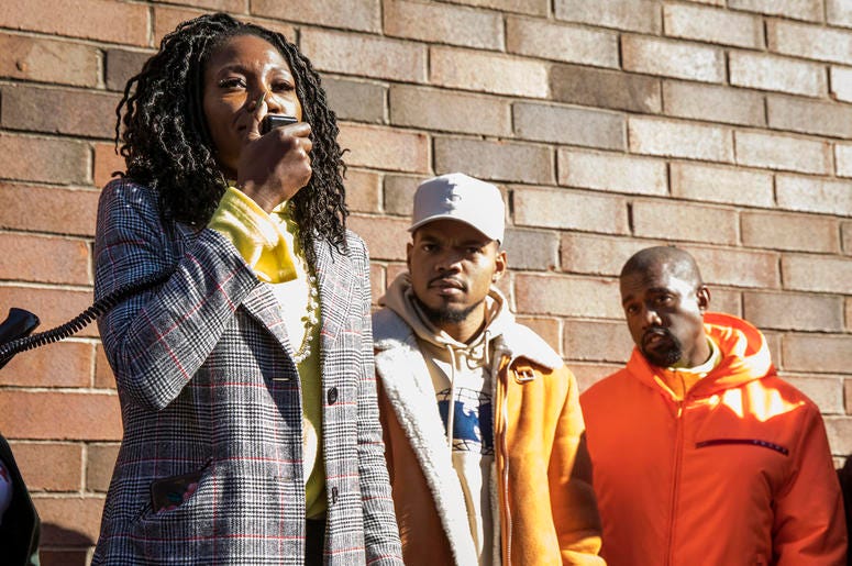 AP18296732137187 Chicago mayoral candidate Amara Enyia speaks as Chance the Rapper, center, and Kanye West listen during a "pull-up" rally for Enyia Tuesday, Oct. 23, 2018, in Chicago. (Ashlee Rezin/Chicago Sun-Times via AP)