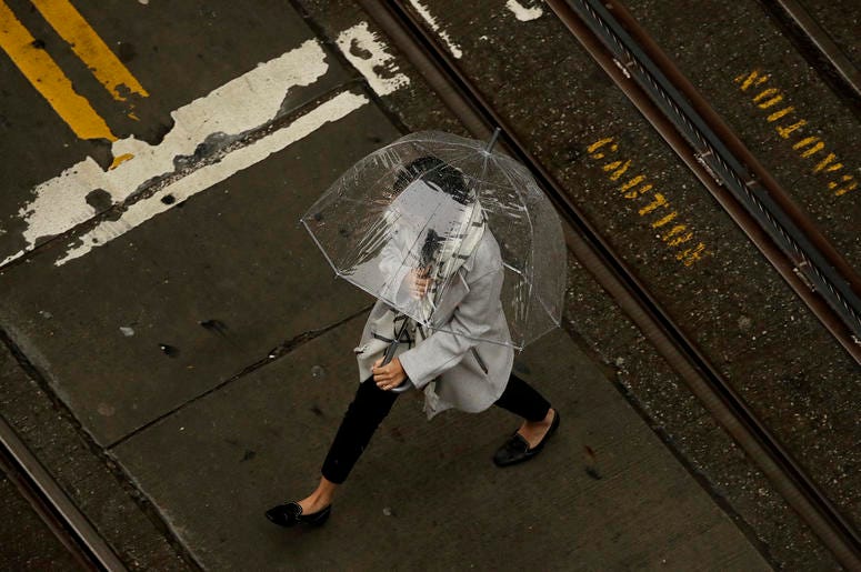 AP19017006526281 A woman walks in the rain while crossing an intersection in San Francisco, Wednesday, Jan. 16, 2019. A series of storms dropped rain up and down the state and snow in mountain regions this week, but the latest storm could be the strongest that Northern Ca
