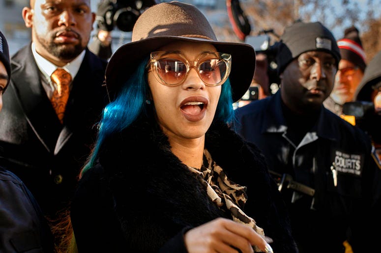 AP19085810205763 This Dec. 7, 2018 file photo shows Rapper Cardi B, center, arriving at Queens County Criminal Court in New York on charges related to a brawl at a New York strip club. (AP Photo/Andres Kudacki, File)