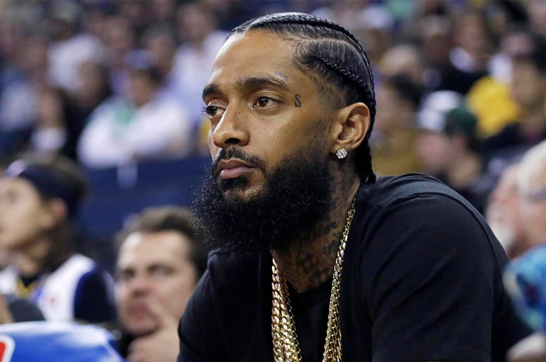 AP19090861774576 In this March 29, 2018, file photo, rapper Nipsey Hussle watches an NBA basketball game between the Golden State Warriors and the Milwaukee Bucks in Oakland, Calif.