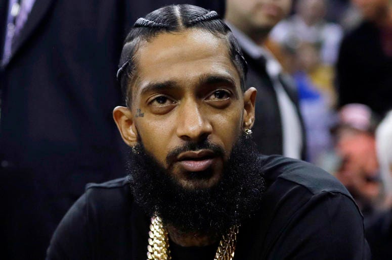 AP19092790586646 This March 29, 2018 file photo shows rapper Nipsey Hussle at an NBA basketball game between the Golden State Warriors and the Milwaukee Bucks in Oakland, Calif. Hussle was shot and killed Sunday, March 31, 2019 outside of his clothing store in Los Angeles