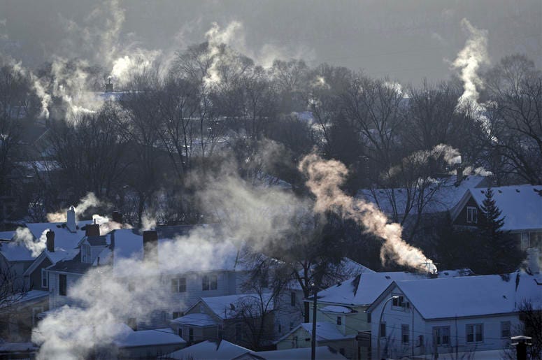 AP19108686034184 In this Wednesday Jan. 30, 2019, file photo smoke rises from the chimneys of homes in St. Paul, Minnesota (Brian Peterson/Star Tribune via AP, File)