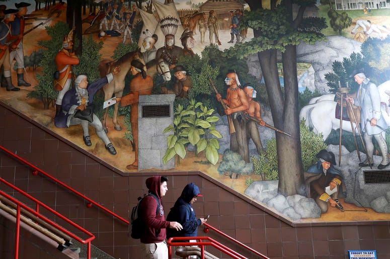 AP19178748483141 In this photo taken April 3, 2019, a pair of students walk past a historic mural that includes slaves and a dead Native American at George Washington High School in San Francisco. (Yalonda M. James/San Francisco Chronicle via AP)