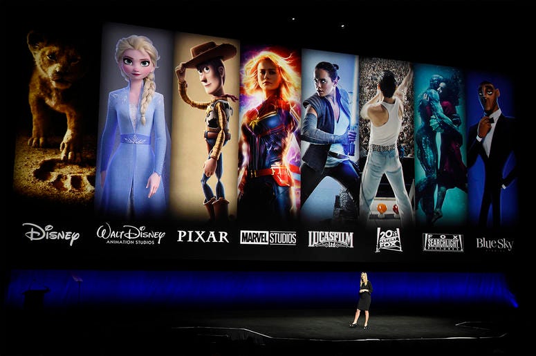 AP19315479666394 In this April 3, 2019, file photo characters from Disney and Fox movies are displayed behind Cathleen Taff, president of distribution, franchise management, business and audience insight for Walt Disney Studios during the Walt Disney Studios Motion Pictur