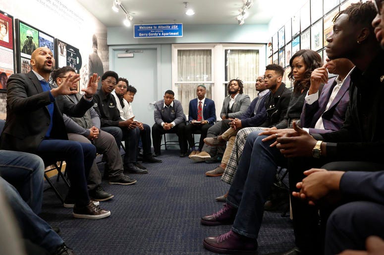 AP18345755041931 Actor Keegan-Michael Key, left, speaks while former First Lady Michelle Obama, right, listens with Wayne State University students at the Motown Museum in Detroit, Tuesday, Dec. 11, 2018. (AP Photo/Paul Sancya)
