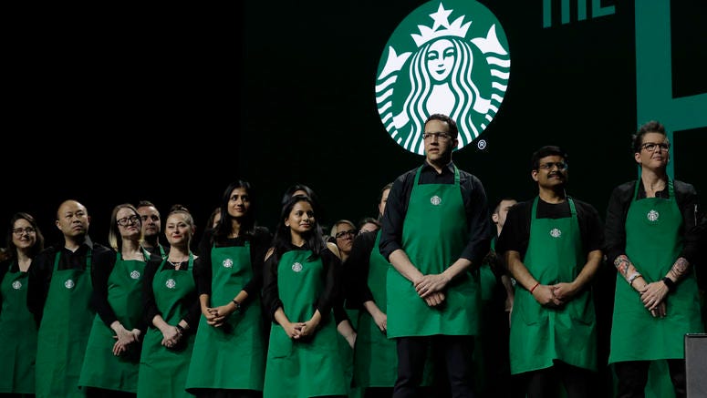 AP19079714317179 Starbucks baristas stand on stage, Wednesday, March 20, 2019, during Starbuck's annual shareholders meeting in Seattle. (AP Photo/Ted S. Warren)