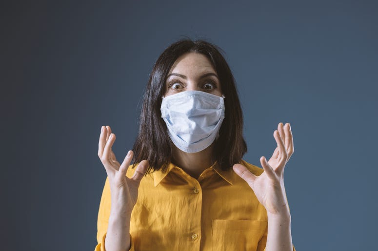 woman with mask on and look of stress