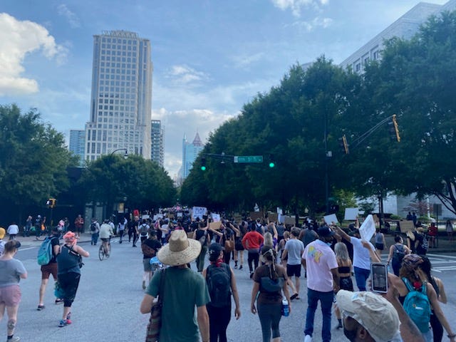 Protesters chanted "Black Lives Matter Too" as they walked down Peachtree Street in Atlanta Tuesday. Protesters chanted "Black Lives Matter Too" as they walked down Peachtree Street in Atlanta Tuesday.