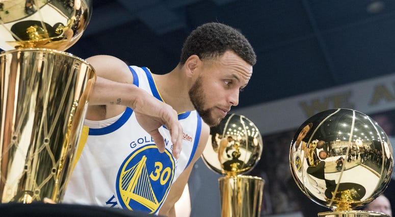 Stephen Curry NBA trophy Stephen Curry of the Golden State Warriors poses with the NBA trophy.