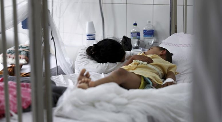 In this Aug. 20, 2019 file photo, a relative embraces a young patient receiving treatment for dengue at the University School Hospital in Tegucigalpa, Honduras. In this Aug. 20, 2019 file photo, a relative embraces a young patient receiving treatment for dengue at the University School Hospital in Tegucigalpa, Honduras.