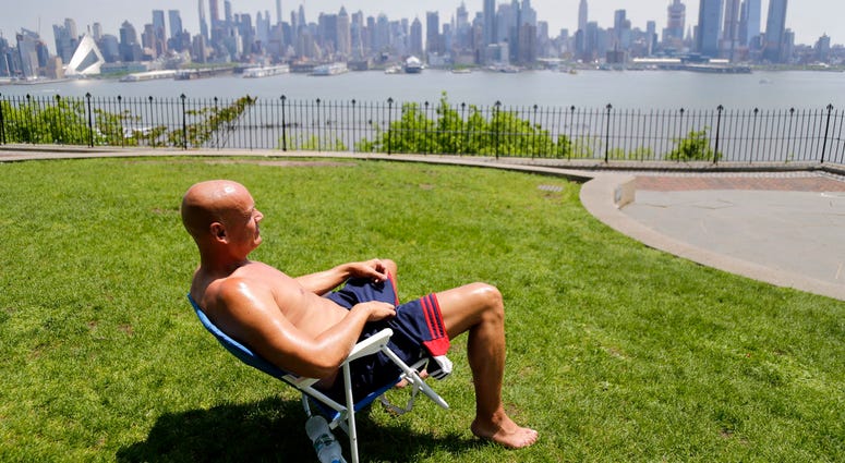 In this Tuesday, May 15, 2018 file photo, Rick Stewart sits in the sunshine with the New York City skyline in the background, in a park in Weehawken, N.J. According to weather records released on Wednesday, June 6, 2018, May reached a record 65.4 degrees