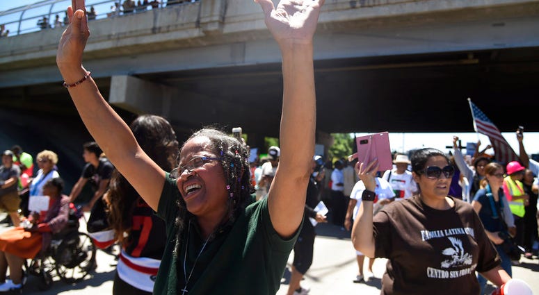 Lavonne Green, left, yells "Hallelujah! Hallelujah!" as protestors walk on the Dan Ryan Expressway, Saturday, July 7, 2018, in Chicago. The protesters shut down the expressway to draw attention to the city's gun violence and pressure public officials to d