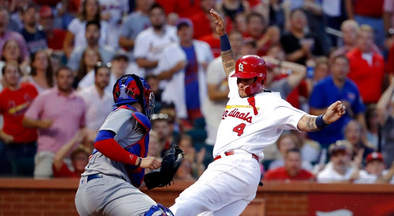 St. Louis Cardinals' Yadier Molina (4) scores past Chicago Cubs catcher Victor Caratini during the third inning of a baseball game Friday, July 27, 2018, in St. Louis. (AP Photo/Jeff Roberson)