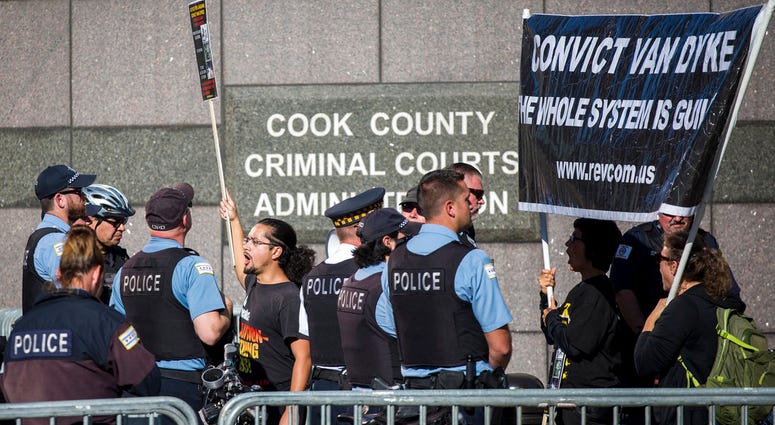 Chicago Police Officers stand guard as protesters rally outside the Leighton Criminal Courthouse in Chicago during the Officer Jason Van Dyke murder trial, Monday morning, Sept. 24, 2018.
