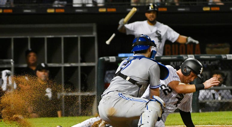 Chicago White Sox's Charlie Tilson (22) scores past Toronto Blue Jays catcher Danny Jansen during the eighth inning of a baseball game Thursday, May 16, 2019, in Chicago. Chicago White Sox's Charlie Tilson (22) scores past Toronto Blue Jays catcher Danny Jansen during the eighth inning of a baseball game Thursday, May 16, 2019, in Chicago.