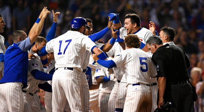 Chicago Cubs' Kyle Schwarber celebrates with teammates at home plate after hitting a solo home run to defeat the Cincinnati Reds 4-3 in the 10th inning of a baseball game Tuesday, July 16, 2019, in Chicago. Chicago Cubs' Kyle Schwarber celebrates with teammates at home plate after hitting a solo home run to defeat the Cincinnati Reds 4-3 in the 10th inning of a baseball game Tuesday, July 16, 2019, in Chicago.