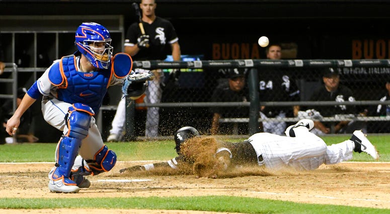 Chicago White Sox's Ryan Goins, right, scores as New York Mets catcher Tomas Nido waits for the throw during the ninth inning of a baseball game, Tuesday, July 30, 2019, in Chicago. Chicago White Sox's Ryan Goins, right, scores as New York Mets catcher Tomas Nido waits for the throw during the ninth inning of a baseball game, Tuesday, July 30, 2019, in Chicago.