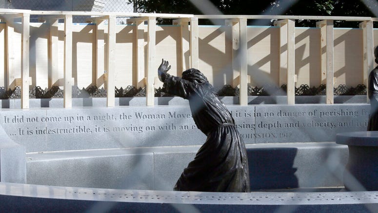 The statue of pioneer woman Laura Ingles is shown behind the fencing put up around the Virginia Women's Memorial on Capitol Square in Richmond, Va., Friday, Jan. 17, 2020.