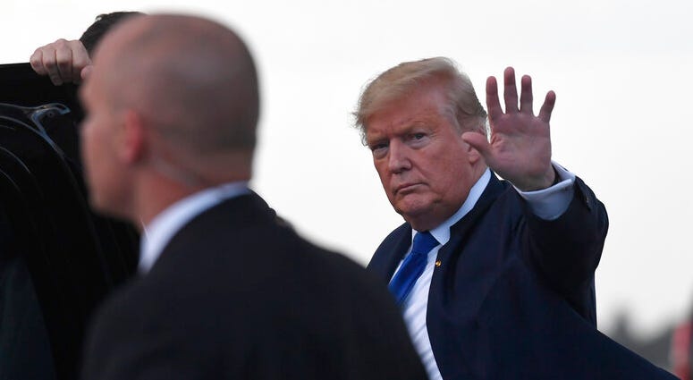 Trump waves before getting into his vehicle after arriving at Palm Beach International Airport in West Palm Beach, Fla., Friday, Jan. 17, 2020.