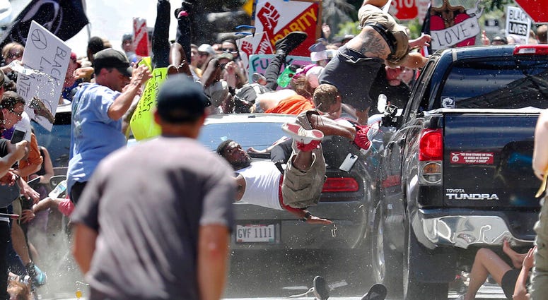 In this Aug. 12, 2017 file photo, people fly into the air as a vehicle drives into a group of protesters demonstrating against a white nationalist rally in Charlottesville, Va. Gov. Ralph Northam said some of the rhetoric used by groups planning to attend white nationalist rally in Charlottesville 2017