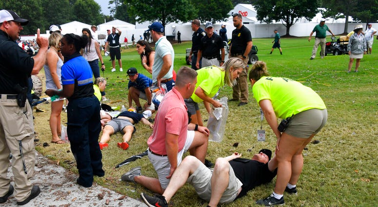 Spectators are tended to after a lightning strike on the course left several injured during a weather delay in the third round of the Tour Championship golf tournament Saturday, Aug. 24, 2019, in Atlanta. Spectators are tended to after a lightning strike on the course left several injured during a weather delay in the third round of the Tour Championship golf tournament Saturday, Aug. 24, 2019, in Atlanta.