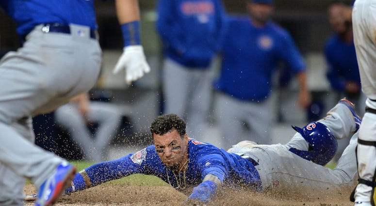 Jul 13, 2018; San Diego, CA, USA; Chicago Cubs second baseman Javier Baez (9) slides in safely to score on a throwing error by San Diego Padres catcher Austin Hedges (not pictured) during the tenth inning at Petco Park. Mandatory Credit: Jake Roth-USA TOD Jul 13, 2018; San Diego, CA, USA; Chicago Cubs second baseman Javier Baez (9) slides in safely to score on a throwing error by San Diego Padres catcher Austin Hedges (not pictured) during the tenth inning at Petco Park. Mandatory Credit: Jake Roth-USA TOD