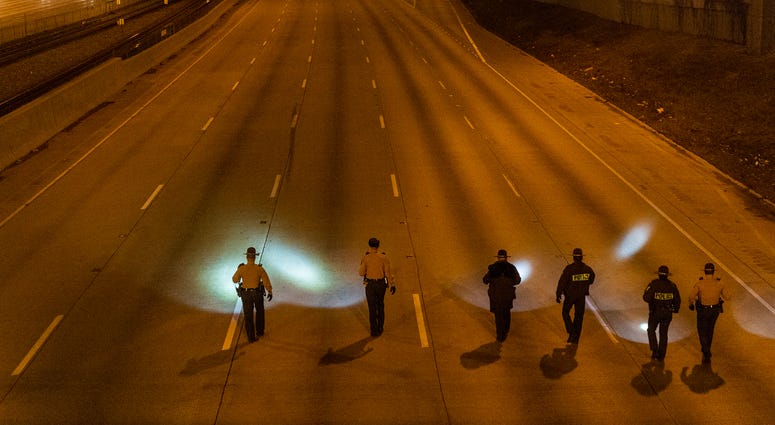 Illinois State Police walk in formation, Friday morning, on the inbound I-94 Expressway near 79th Street, looking for evidence of the shooting that left one woman wounded. Illinois State Police walk in formation, Friday morning, on the inbound I-94 Expressway near 79th Street, looking for evidence of the shooting that left one woman wounded.