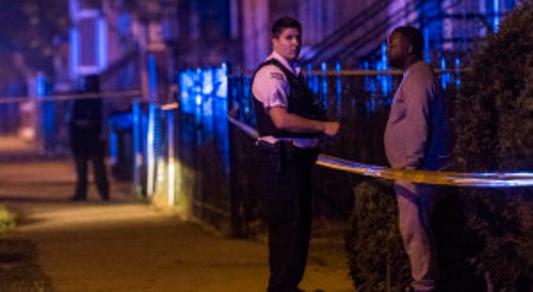 Police investigate a scene where multiple people were shot Sunday morning in the 6400 block of South Eberhart Ave.