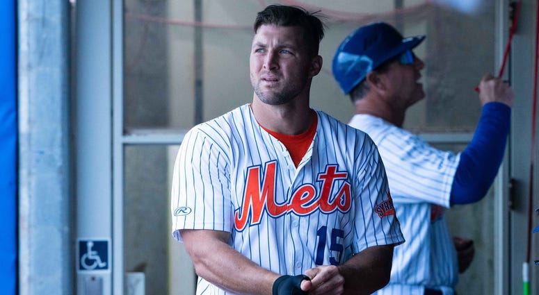 Tim Tebow Tim Tebow takes off his batting gloves in the dugout of the Triple-A Syracuse Mets.