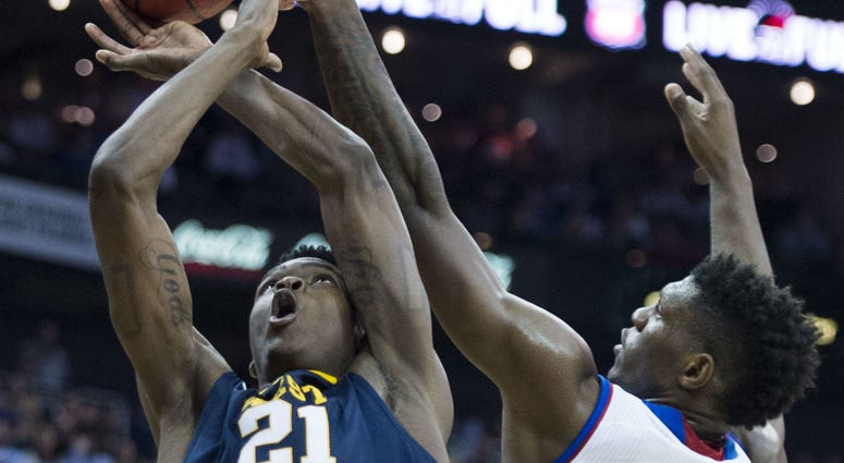 KU's Silvio De Sousa (22) knocks the ball out of the hands of West Virginia's Wesley Harris (21) during the first half in the Big 12 Tournament championship game at the Sprint Center in Kansas City, Mo., on Saturday, March 10, 2018.