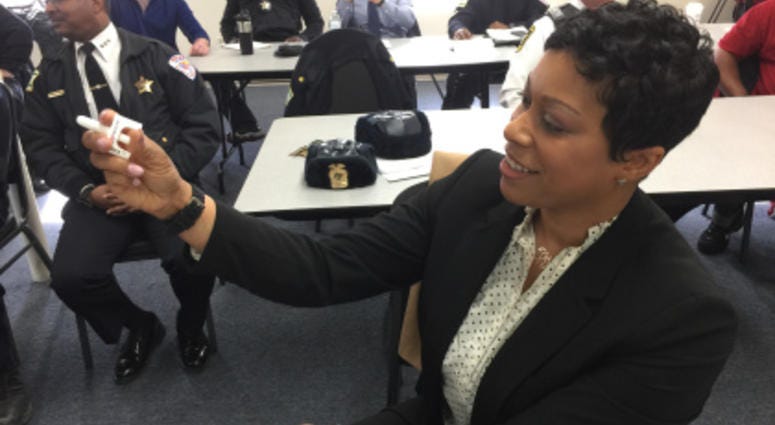 Maywood Police Detective Angela Patterson demonstrates how simple it is to administer a Narcan spray