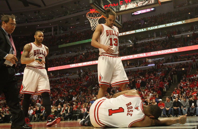 Players and trainers rush to the aid of the Chicago Bulls' Derrick Rose (1) after he injured his knee in the closing minutes of the fourth quarter against the Philadelphia 76ers in Game 1 of the Eastern Conference first-round series at the United Center