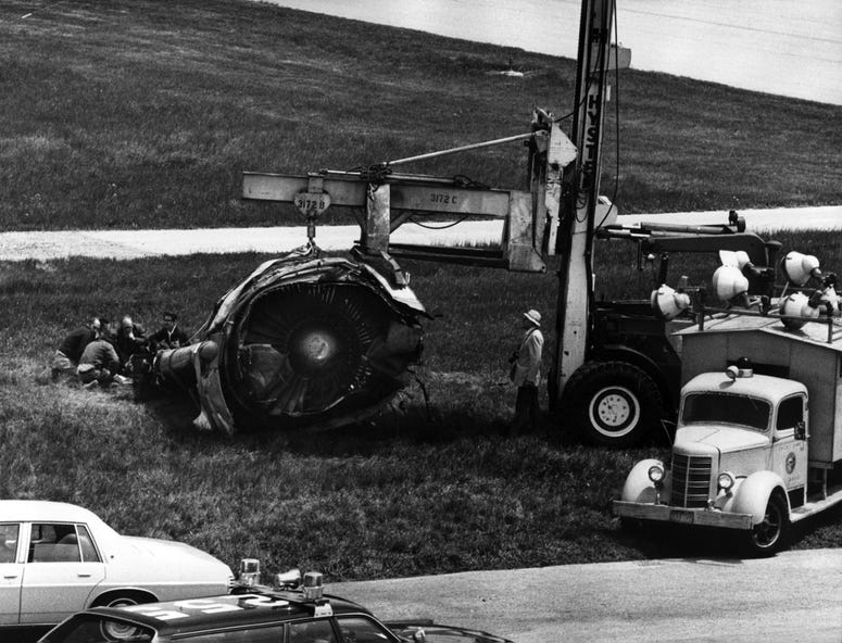 The DC-10 engine lays on the grass just east of Runway 32, right, where it stopped after falling from American Airlines Flight 191, just as the plane rotated from the runway, May 26, 1979. Investigators examine the engine. The DC-10 engine lays on the grass just east of Runway 32, right, where it stopped after falling from American Airlines Flight 191, just as the plane rotated from the runway, May 26, 1979. Investigators examine the engine.