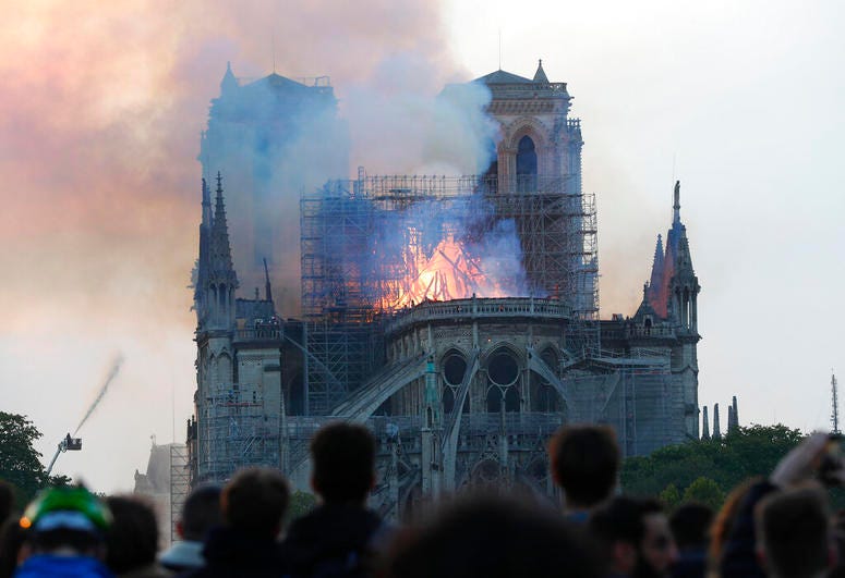 People watch as flames and smoke rise from Notre Dame cathedral as it burns in Paris, Monday, April 15, 2019. People watch as flames and smoke rise from Notre Dame cathedral as it burns in Paris, Monday, April 15, 2019.