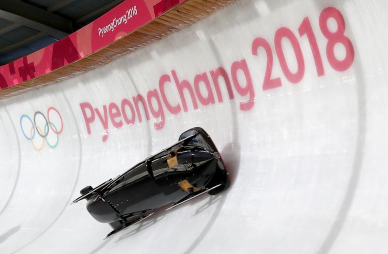 eb 7, 2018; Pyeongchang, KOR; The Team Canada bobsled, piloted by Nick Poloniato, ends up on its side going through turn fourteen Feb 7, 2018; Pyeongchang, KOR; A worker sprays down the bobsled track at turn fourteen between bobsled training sessions at t
