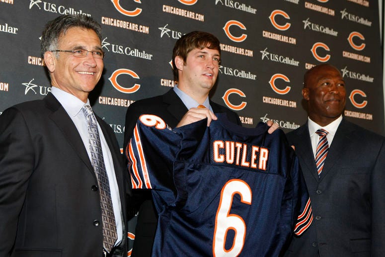 Chicago Bears general manager Jerry Angelo, left, and Bears head coach Lovie Smith, right, pose with Jay Cutler, who was introduced as the new quarterback for Chicago at a news conference on Friday, April 3, 2009
