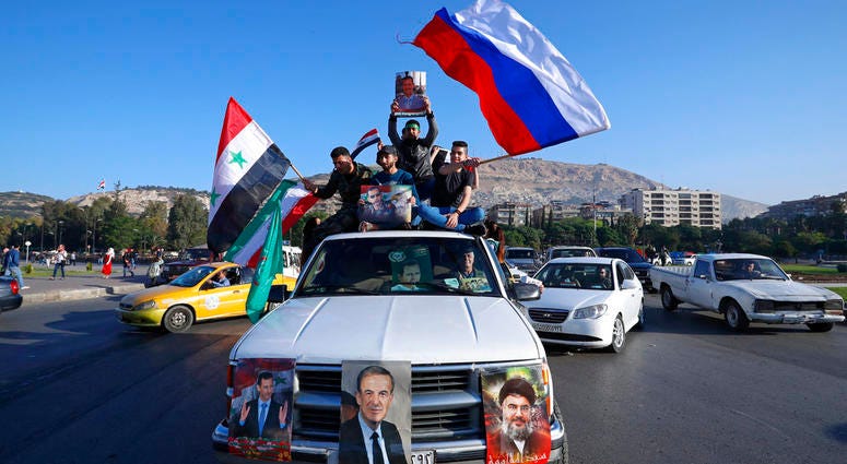 Syrian demonstrators Syrian government supporters wave Syrian, Iranian and Russian flags as they chant slogans against U.S. President Trump during demonstrations following a wave of U.S., British and French military strikes to punish President Bashar Assad.