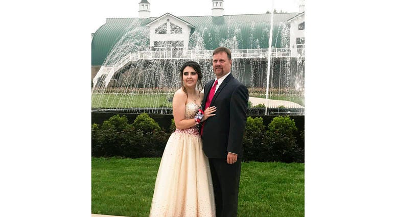 In this Saturday, May 19, 2018, photo provided by Kelly Brown, James Buchanan High School senior Kaylee Suders and Robert Brown pose for a photo at Green Grove Gardens in Greencastle, Pa.