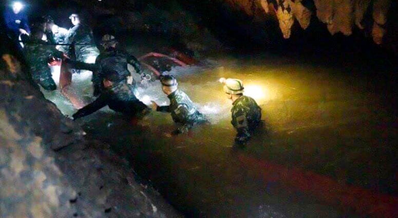 hai rescue teams walk inside cave complex where 12 boys and their soccer coach went missing, in Mae Sai, Chiang Rai province, in northern Thailand, Monday, July 2, 2018.