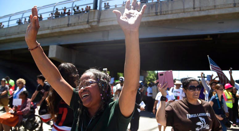 Lavonne Green, left, yells "Hallelujah! Hallelujah!" as protestors walk on the Dan Ryan Expressway, Saturday, July 7, 2018, in Chicago. The protesters shut down the expressway to draw attention to the city's gun violence and pressure public officials to d