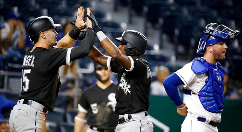 Chicago White Sox's Tim Anderson, center, celebrates with Adam Engel (15) as he crosses the plate past Kansas City Royals catcher Cam Gallagher after hitting a two-run home run during the 12th inning of a baseball game Wednesday, Sept. 12, 2018