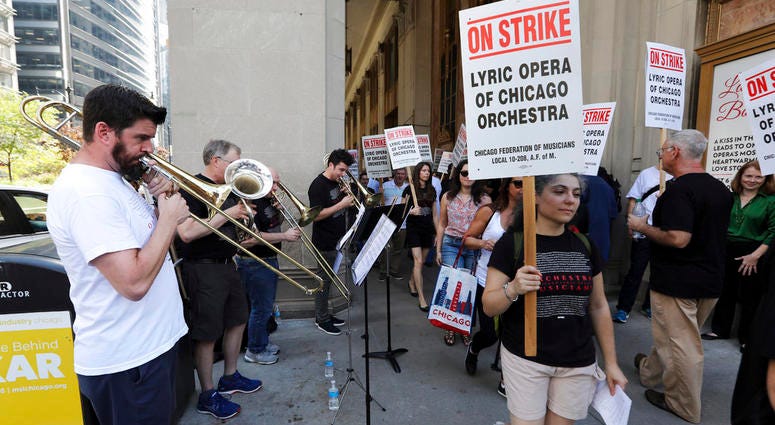 Jeremy Mueller, left, and other striking Lyric Opera musicians perform as their colleagues picket outside The Civic Opera House in Chicago on Tuesday, Oct. 9, 2018. (Terrence Antonio James/Chicago Tribune via AP) Jeremy Mueller, left, and other striking Lyric Opera musicians perform as their colleagues picket outside The Civic Opera House in Chicago on Tuesday, Oct. 9, 2018. (Terrence Antonio James/Chicago Tribune via AP)