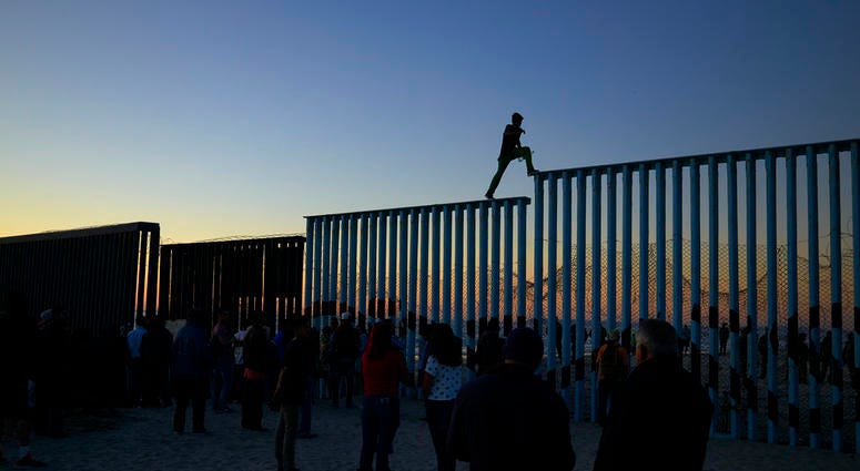 In this Nov. 14, 2018 picture, a man from Honduras walks along the top of the border structure separating Mexico and the United States, in Tijuana, Mexico. With about 3,000 Central American migrants having reached the Mexican border across from California In this Nov. 14, 2018 picture, a man from Honduras walks along the top of the border structure separating Mexico and the United States, in Tijuana, Mexico. With about 3,000 Central American migrants having reached the Mexican border across from California