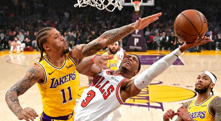 Chicago Bulls guard Shaquille Harrison, center, shoots as Los Angeles Lakers forward Michael Beasley, left, defends along with forward Brandon Ingram during the first half of an NBA basketball game Tuesday, Jan. 15, 2019, in Los Angeles.