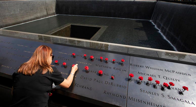 Norma Molina, of San Antonio, Texas, leaves flowers by the names of firefighters from Engine 33 at the September 11 Memorial, Monday, Sept. 9, 2019, in New York. Norma Molina, of San Antonio, Texas, leaves flowers by the names of firefighters from Engine 33 at the September 11 Memorial, Monday, Sept. 9, 2019, in New York.