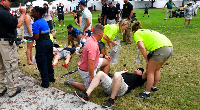 Spectators are tended to after a lightning strike on the course left several injured during a weather delay in the third round of the Tour Championship golf tournament Saturday, Aug. 24, 2019, in Atlanta. Spectators are tended to after a lightning strike on the course left several injured during a weather delay in the third round of the Tour Championship golf tournament Saturday, Aug. 24, 2019, in Atlanta.