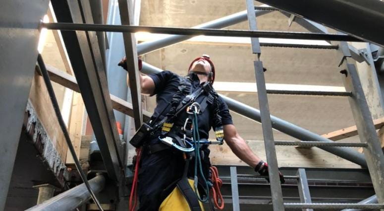 An Evanston firefighter works to bring a crane operator down from his post after a fatal construction accident in the 800 block of Emerson Street in Evanston.